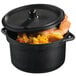 A Solia black plastic mini cooking pot with a lid full of food.