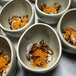 A close-up of a group of Front of the House Tides porcelain bowls filled with fish eggs.