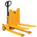 A yellow pallet truck with a handle on top.