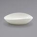 A white Front of the House Tides scallop oval bowl on a gray surface.