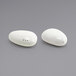 A white porcelain salt and pepper shaker set with a scalloped edge and holes on a white background.