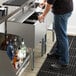 A man putting ice in a glass from a Regency underbar ice bin.