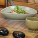 A Front of the House Tides oval porcelain bowl filled with food on a table.