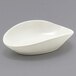 A white Front of the House Tides scallop oval ramekin on a gray surface.