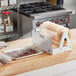 A person using Berry Standard Miler film to cover a tray of cookies on a counter.