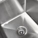 A stainless steel Advance Tabco four compartment pot sink with two drainboards and a sink drain.