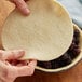 A person's hand holding a Pillsbury pie crust