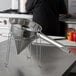 A stainless steel Choice fine china cap strainer on a counter.