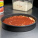 A deep dish pizza in an American Metalcraft hard coat anodized aluminum pan.