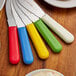 A group of Dexter-Russell sandwich spreaders with different colored handles.