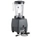 A Waring commercial food blender with a clear container and a cord.