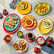 A table in a Mexican restaurant with a variety of colorful stoneware bowls filled with food.