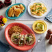 An Acopa Capri Caribbean turquoise stoneware platter with food on a table.