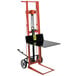 A red and black hydraulic Pedalift with a black table on top.
