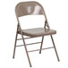 A beige Flash Furniture metal folding chair.