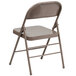 A beige metal folding chair.