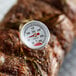 A Cooper-Atkins pocket probe thermometer placed on a piece of meat.