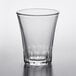 A clear Duralex shot glass on a white surface.