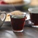 A Duralex Picardie glass filled with hot tea on a table.