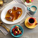 A yellow Acopa Capri saucer holding a cup of coffee on a table with a piece of pie.