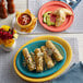 A Acopa Capri white stoneware saucer with corn on the cob on it.