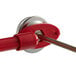 A Cooper-Atkins pocket probe dial thermometer with a red and silver metal handle and round metal object.