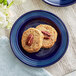Two Acopa Capri deep sea cobalt stoneware plates with cookies and pecans on them.