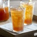 A tray with two Duralex Picardie Highball Glasses filled with iced tea and lemon slices.