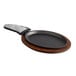 A Valor pre-seasoned cast iron fajita skillet with a grey silicone handle on a wood underliner.