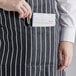 A woman wearing a black and white striped bib apron with pockets.