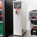 A Bloomfield hot water dispenser on a counter with a drink dispenser.