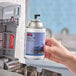 A person holding a Rubbermaid Microburst 9000 Mountain Peaks air freshener refill can.