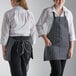 Two women wearing black and white striped Choice bib aprons.