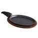 A Valor pre-seasoned cast iron fajita skillet with a wooden underliner and handle cover.