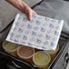 a hand holding a bag with plastic containers of liquid