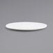 A close-up of a white Front of the House Canvas round porcelain plate with a small rim on a gray surface.