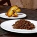 A white plate with brown food on it.