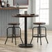 A Lancaster Table & Seating cast iron counter height table base with wooden stools.