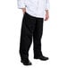 A man wearing Chef Revival black chef pants and a white shirt.