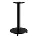 A black Lancaster Table & Seating cast iron table base with a pedestal on a white table.