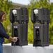 A woman washing her hands in a black plastic Cambro handwash station.