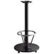 A Lancaster Table & Seating black cast iron bar height table base with a foot rest and table equalizers.