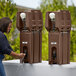 A woman using a Cambro brown portable handwash station.