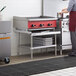 A woman using a Regency stainless steel equipment stand in a commercial kitchen.