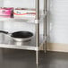 A Regency stainless steel work table with a pan on the undershelf.