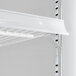 A white shelf with metal brackets inside a glass door merchandiser freezer.
