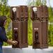 A woman washing her hands in a brown Cambro portable handwash station.