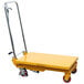 A yellow Wesco Industrial Products scissor lift table with wheels.