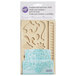 A white Wilton silicone mold with a blue lace design.