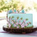 a cake with flowers and birds on top